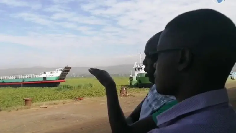 A cargo ship attempting to dock at the water hyacinth-filled Kisumu Port.