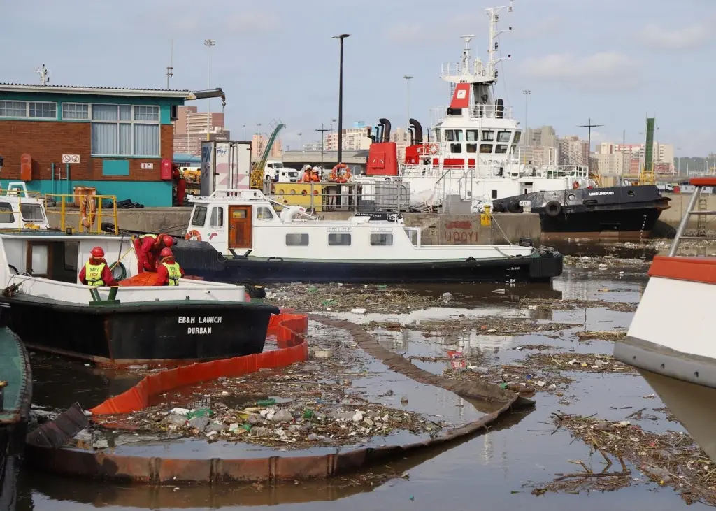 An African port. A large amount of solid waste floats on the surface of the water around the ships.