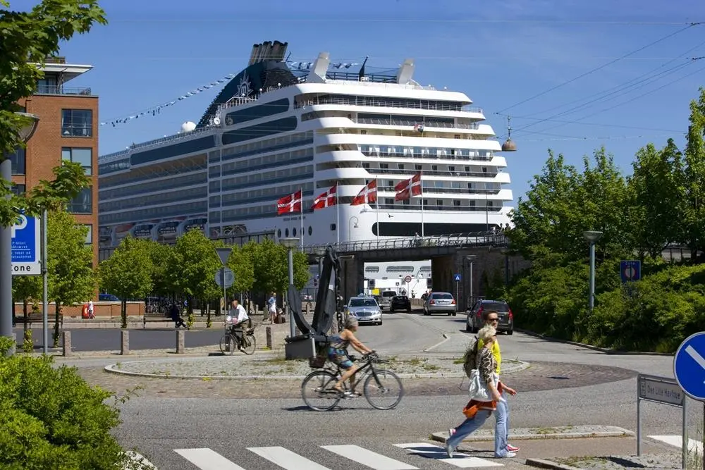 Pedestrians and cyclists in Copenhagen with cruise ship docked nearby