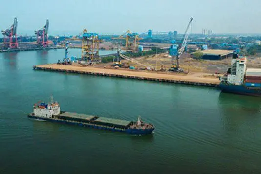 The image shows an overhead shot of a ship entering JSW Mangalore Container Terminal Pvt. Ltd