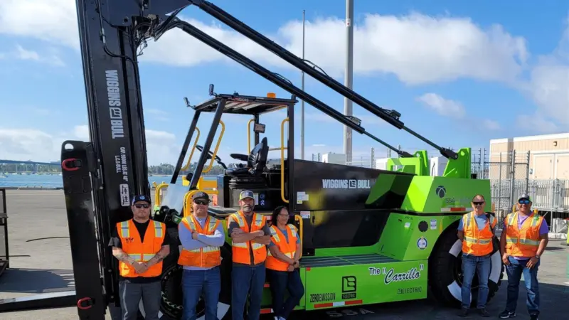 The image shows the San Diego battery electric forklift with the crew posing in front