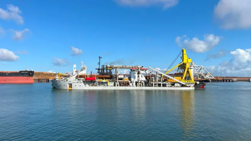 The image shows the vessel J.F.J. De Nul performing dredging and reclamation works in Port Hedland
