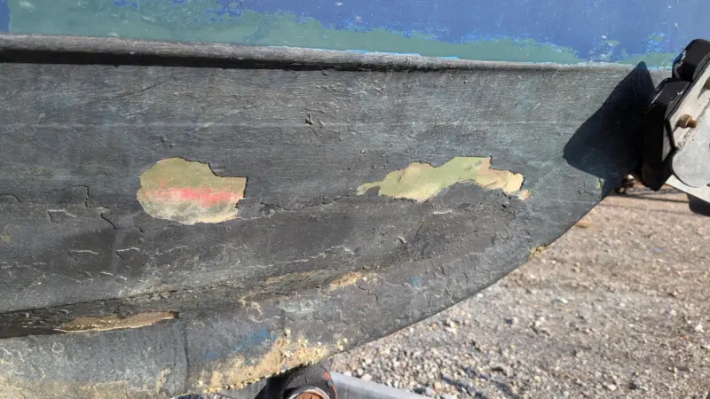 The image shows a degrading hull of a recreational vessel