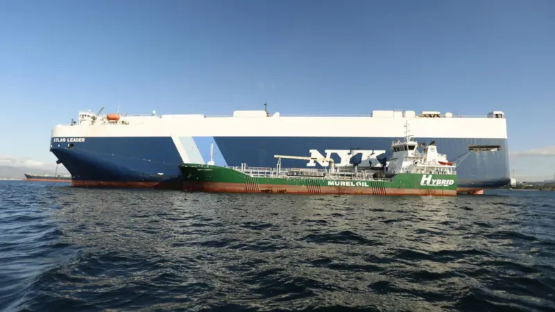 The picture shows NYK Line’s Atlas Leader being bunkered with biofuels by Cepsa’s electric port hybrid barge, Bahía Levante