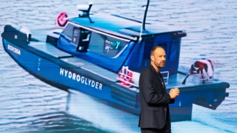 Yinson GreenTech employee standing in front of an image of the Hydroglyder fully electric hydrofoil