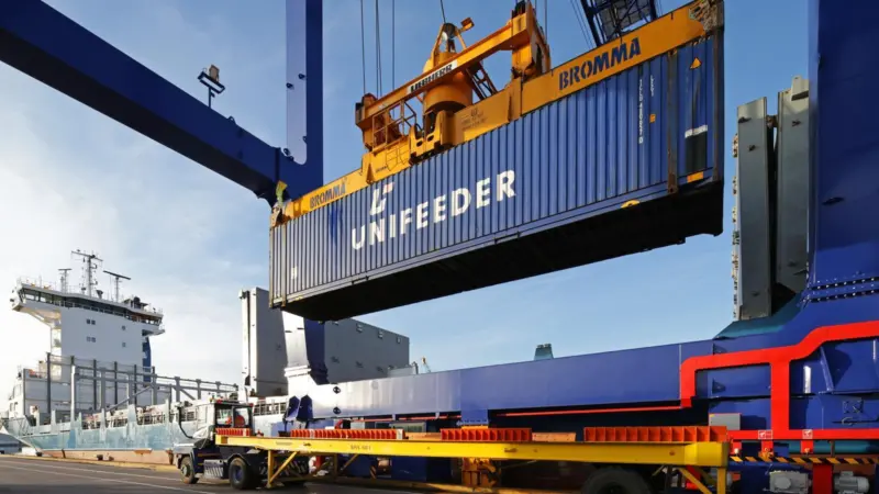 The image shows a Unifeeder container being lifted on the quayside