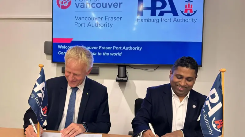 The image shows port execs from both ports signing the MoU