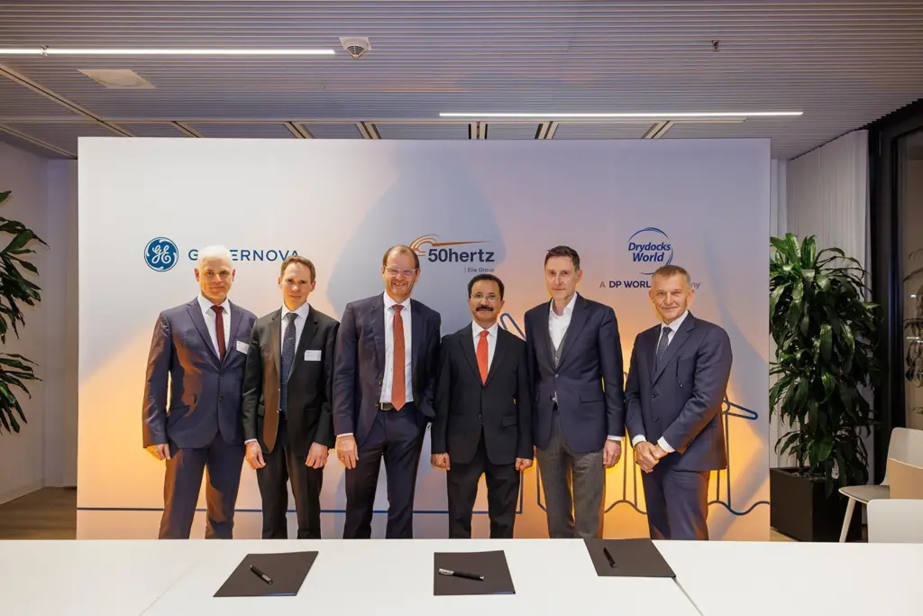 The image shows six representatives from the companies at the project signing