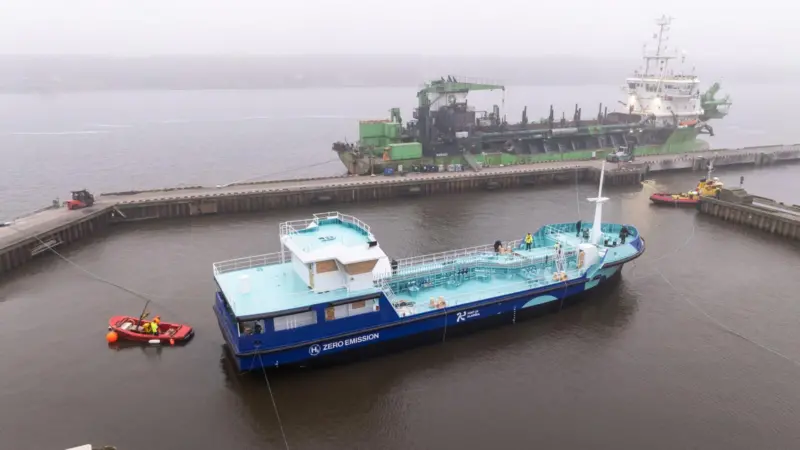 The image shows Lithuania's first electric/green hydrogen powered port tanker