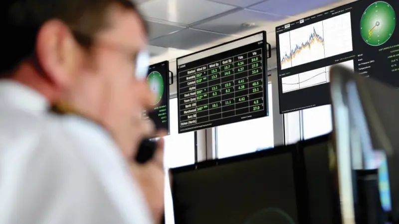 The image shows an operator in front of computer screens displaying OceanWise’s Port-Log Forecast Extension in action