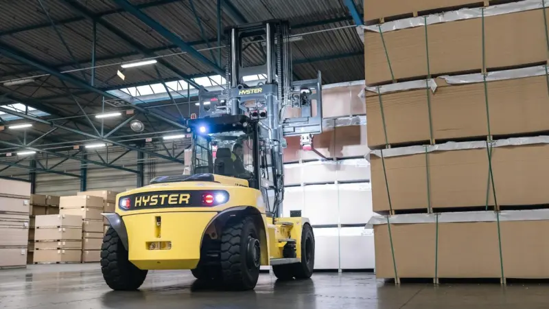 The image shows a Hyster J10-18XD in operation at a warehouse