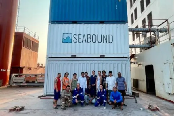 The image shows the Seabound team posing with the carbon capture technology on the quayside