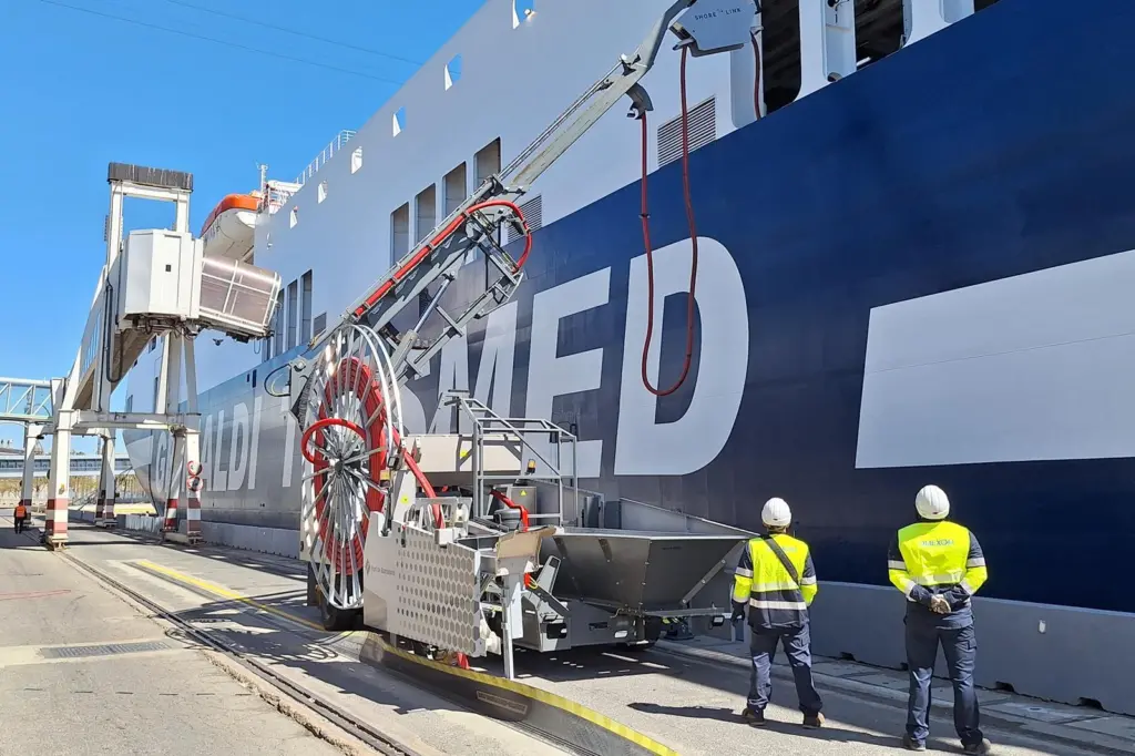 The image shows two operators checking the OPS cabling management system to ensure the connection to the ship quayside