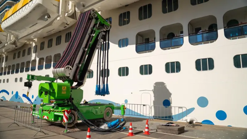 The image shows a cruise vessel plugged into shore power on the quayside