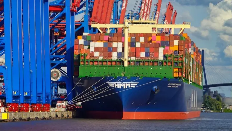 The image shows a Hamburg container terminal with a ship on the quayside