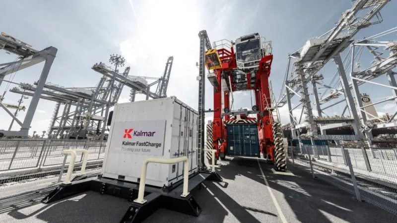 The image shows a Kalmar electric straddle and charging infrastructure