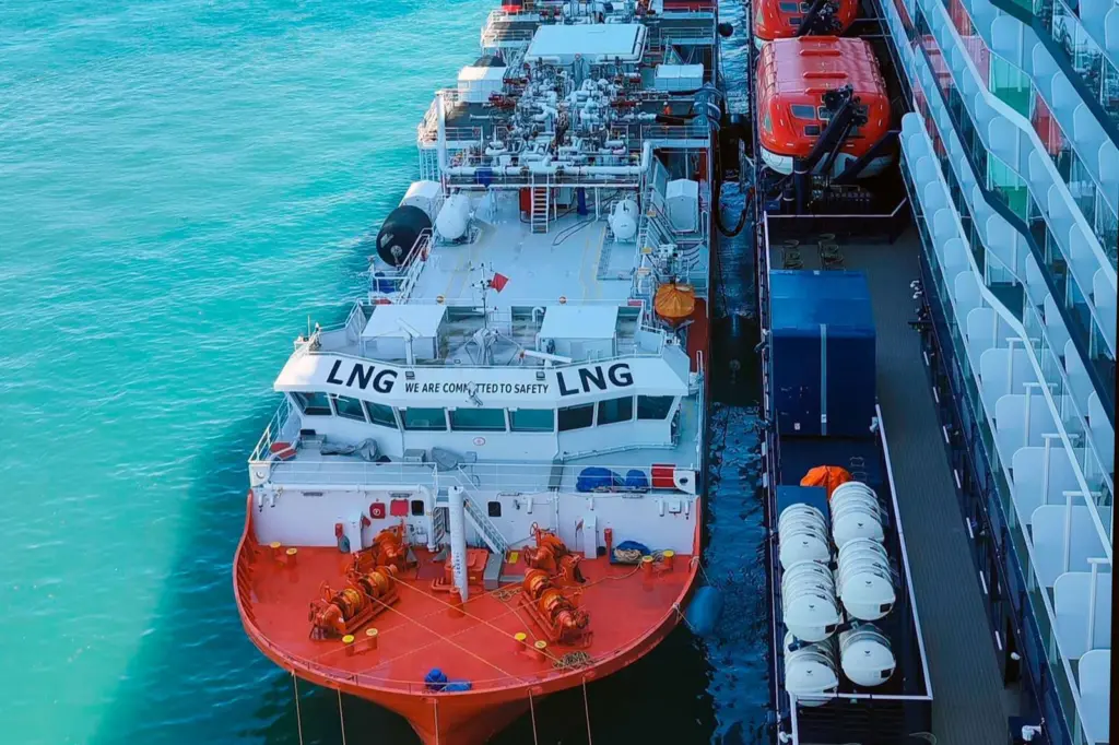 The image shows the bioLNG bunkering operation at Barcelona between the barge Haugesund Knutsen and the cruise ship Mein Schiff Relax