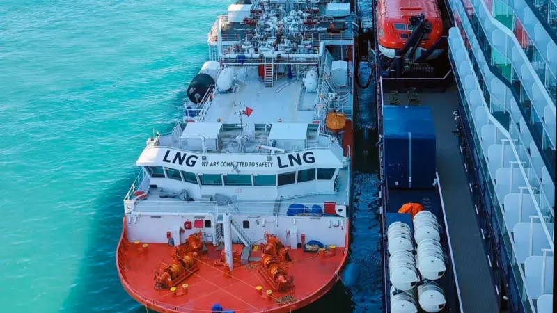 The image shows the bioLNG bunkering operation at Barcelona between the barge Haugesund Knutsen and the cruise ship Mein Schiff Relax