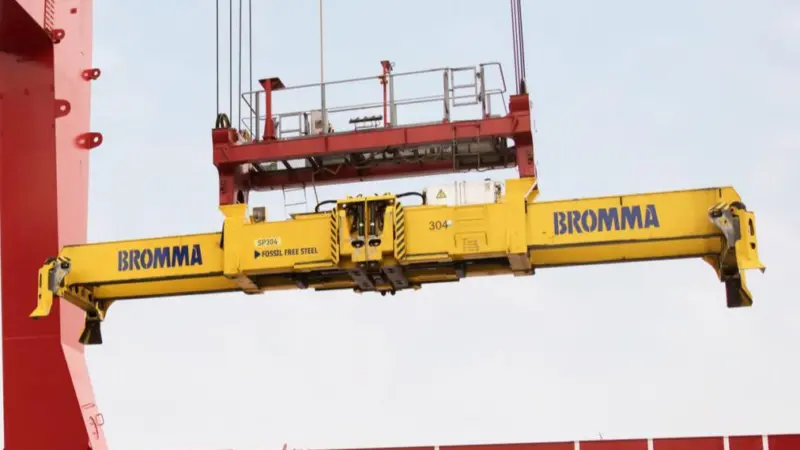 The image shows a Bromma spreader in action on the quayside