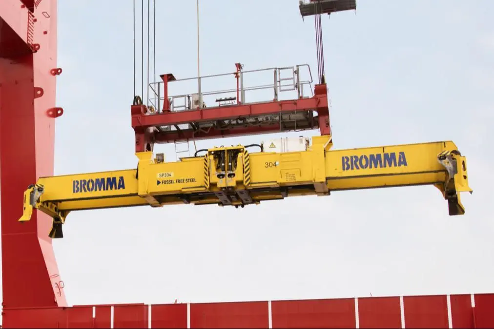 The image shows a Bromma spreader in action on the quayside