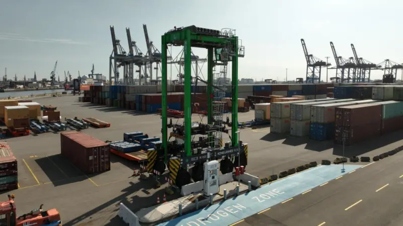 The hydrogen straddle carrier pictured on the quayside at Container Terminal Tollerort
