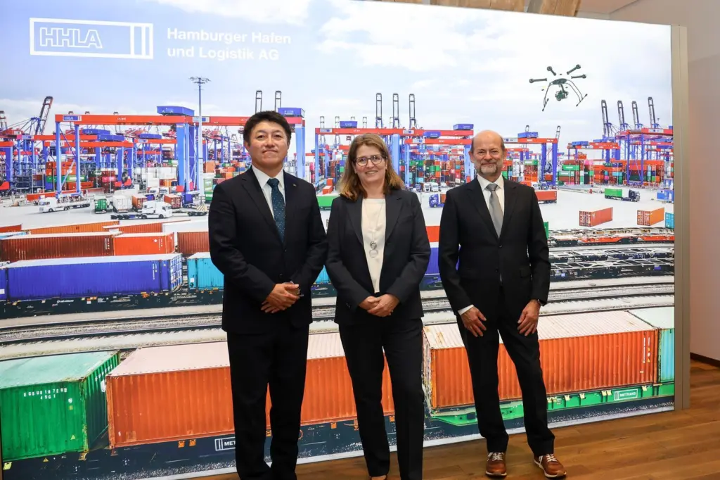 The image shows the MoU signing with Kei Nomura (Kawasaki Heavy Industries, Ltd.), Annette Walter (HHLA), Dr. Manfred Schuckert (Daimler Truck AG)