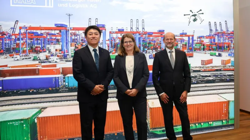 The image shows the MoU signing with Kei Nomura (Kawasaki Heavy Industries, Ltd.), Annette Walter (HHLA), Dr. Manfred Schuckert (Daimler Truck AG)