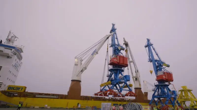 The image shows the Rikon all-electric double jib level luffing cranes on the quayside at the Port of Riga