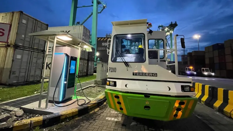The image shows the electric prime mover fleet on the quayside at the Port of Tanjung Pelepas