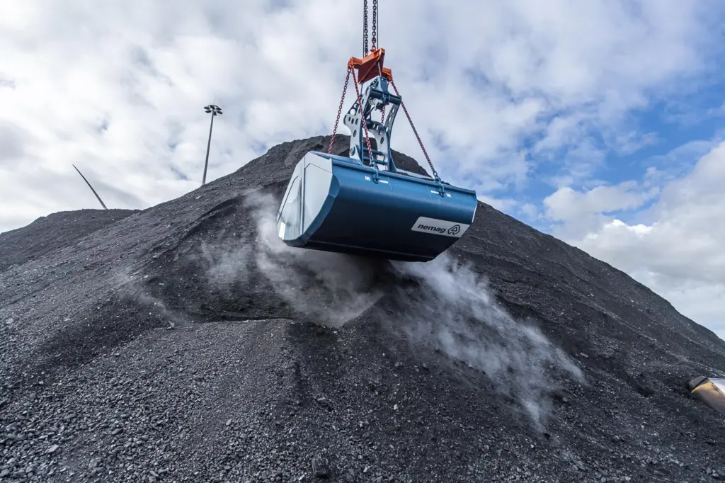 A close up of a Nemag grab handling coal