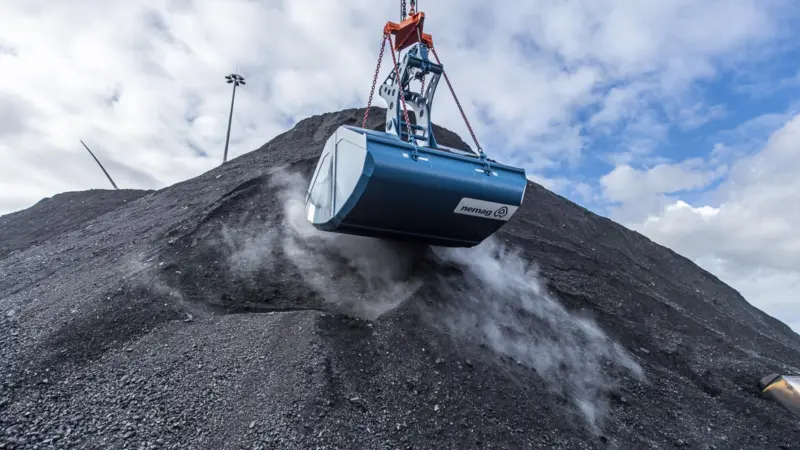 A close up of a Nemag grab handling coal