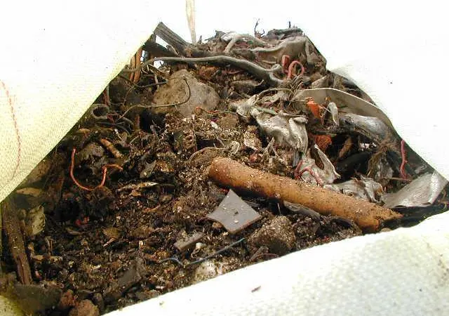 Shredded_car_waste_from_breakup_at_Lands_end_being_lifted_out.jpg