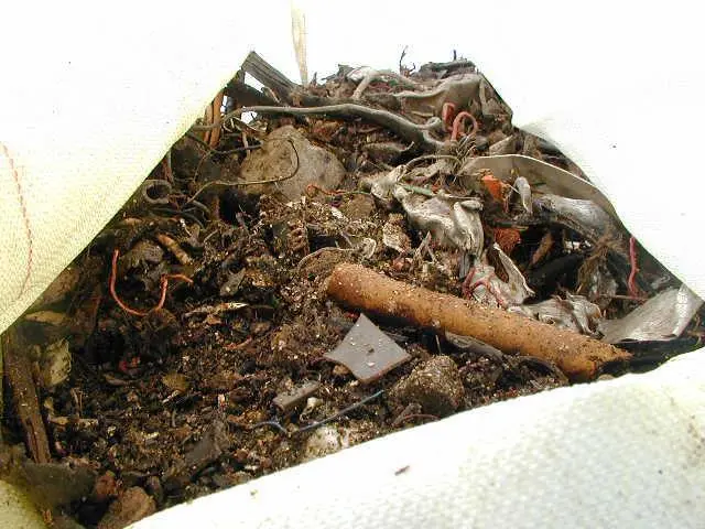 Shredded_car_waste_from_breakup_at_Lands_end_being_lifted_out.jpg