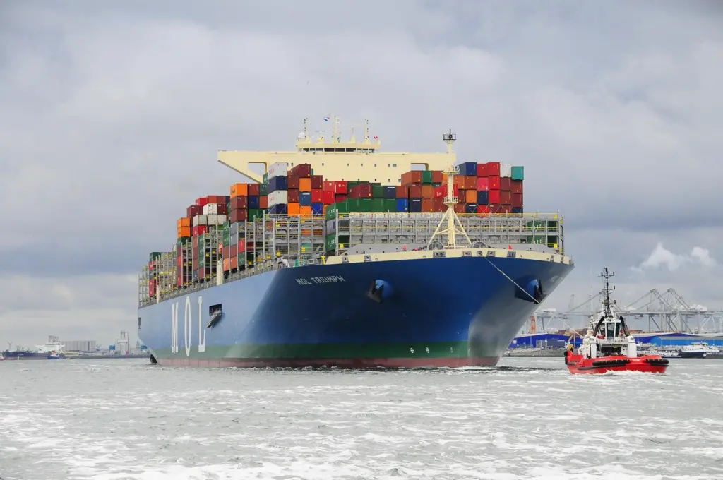 A bulk cargo carrier being pulled by a tugboat.