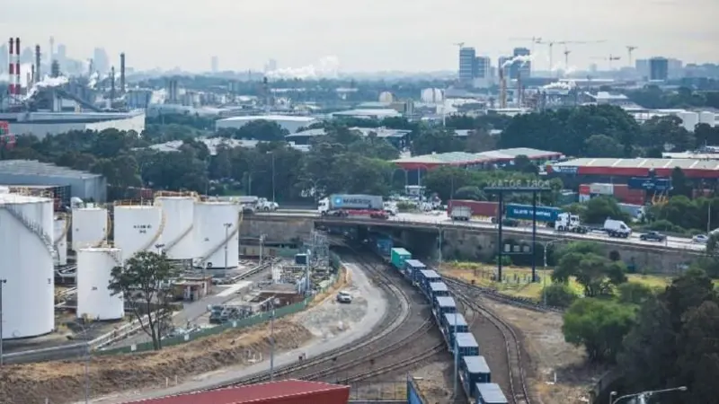 A rail shuttle entering Port Botany, with the Sydney city skyline in the distance