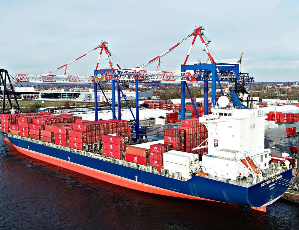 Cargo ship at dock with containers about to be unloaded by Liebherr STS cranes