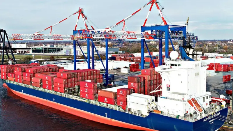 Cargo ship at dock with containers about to be unloaded by Liebherr STS cranes
