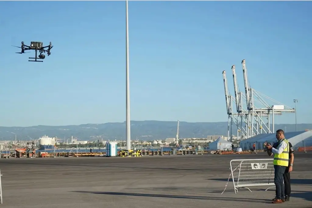 The picture shows a drone being flown by an operator at the Port of Tarragona