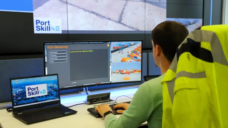 The image shows an HHLA employee testing the training control centre developed as part of PortSkill 4.0 at the CTA