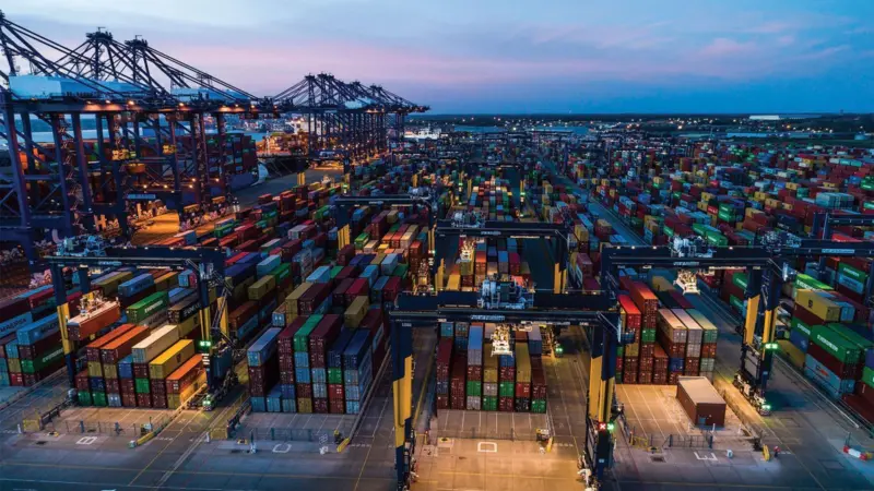 Containers at the Port of Felixstowe with ship-to-shore cranes on the left and two ships just visible