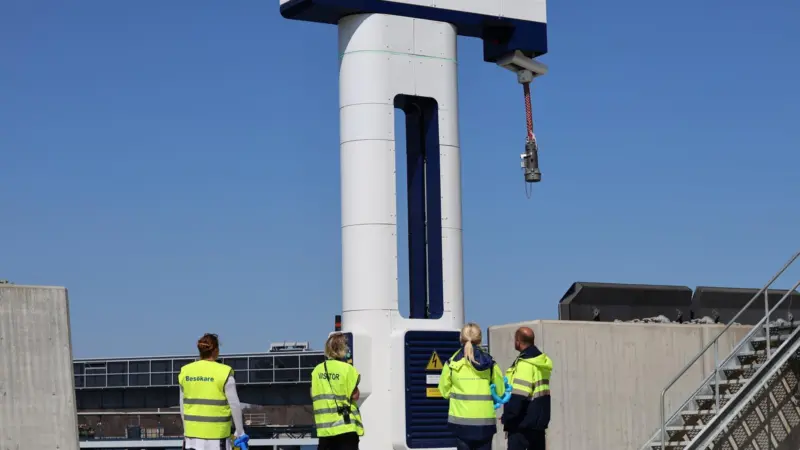 onshore power connection at the Port of Kapellskär in Stockholm with four workers in hi-viz standing at its base