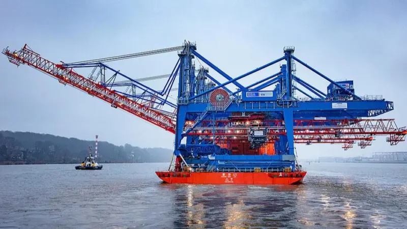 The image shows the new Liebherr cranes being delivered into HHLA CTA