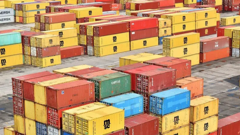 The image shows cargo boxes on the quayside