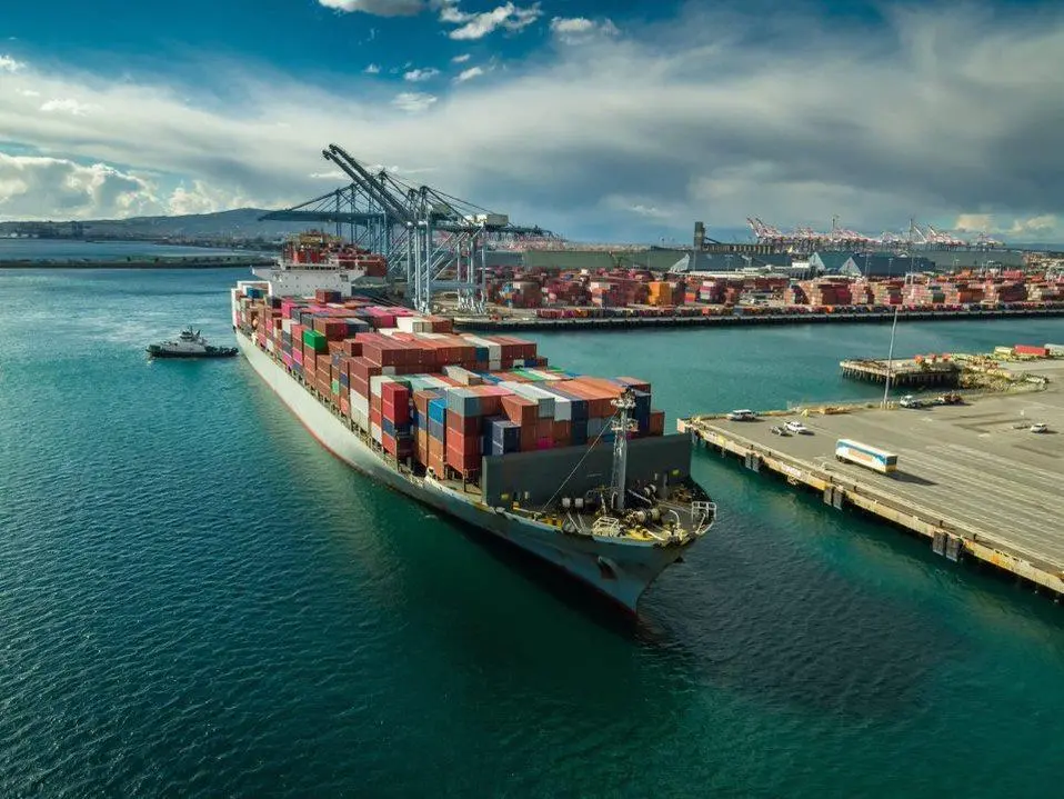 A container ship at port with a crane behind