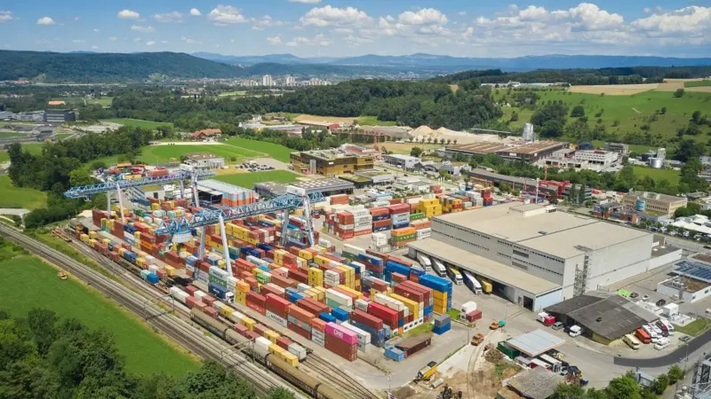 Containers and a large warehouse under a blue sky