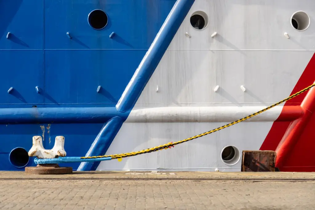 A close-up of a moored ship in red, white and blue