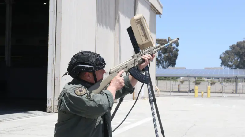 Man with rifle pointing it at the sky looking for pretend drones