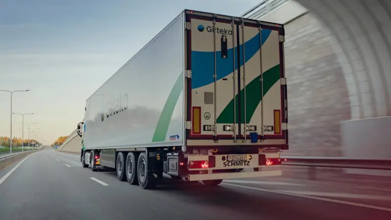 The image shows a Girteka cargo truck on the road