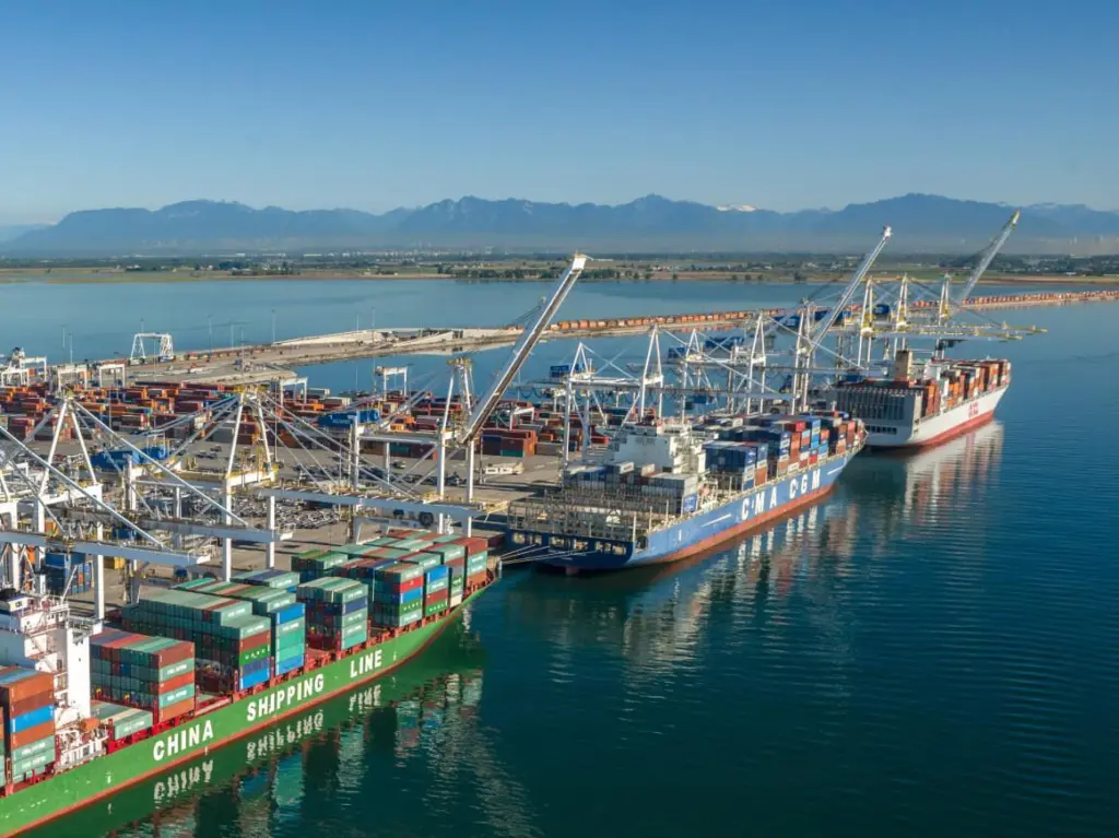 Three container ships at dock in Deltaport, Canada with cranes shoreside