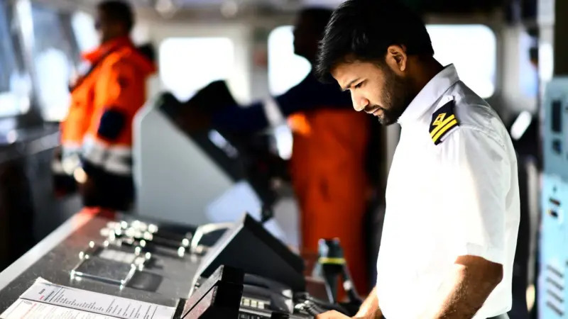 A ship's officer looks at bridge equipment
